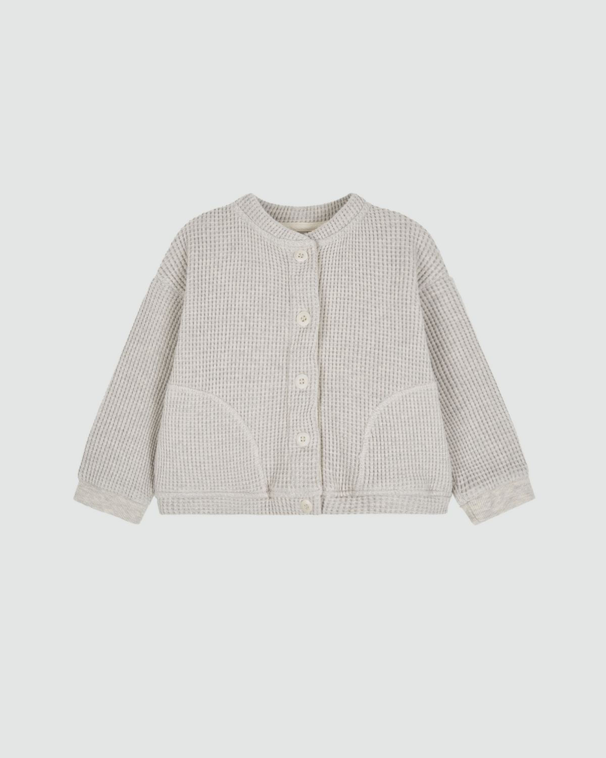 `The Fruto Natural Button Cardigan in Oat, a textured waffle-knit cardigan with natural buttons and front patch pockets.